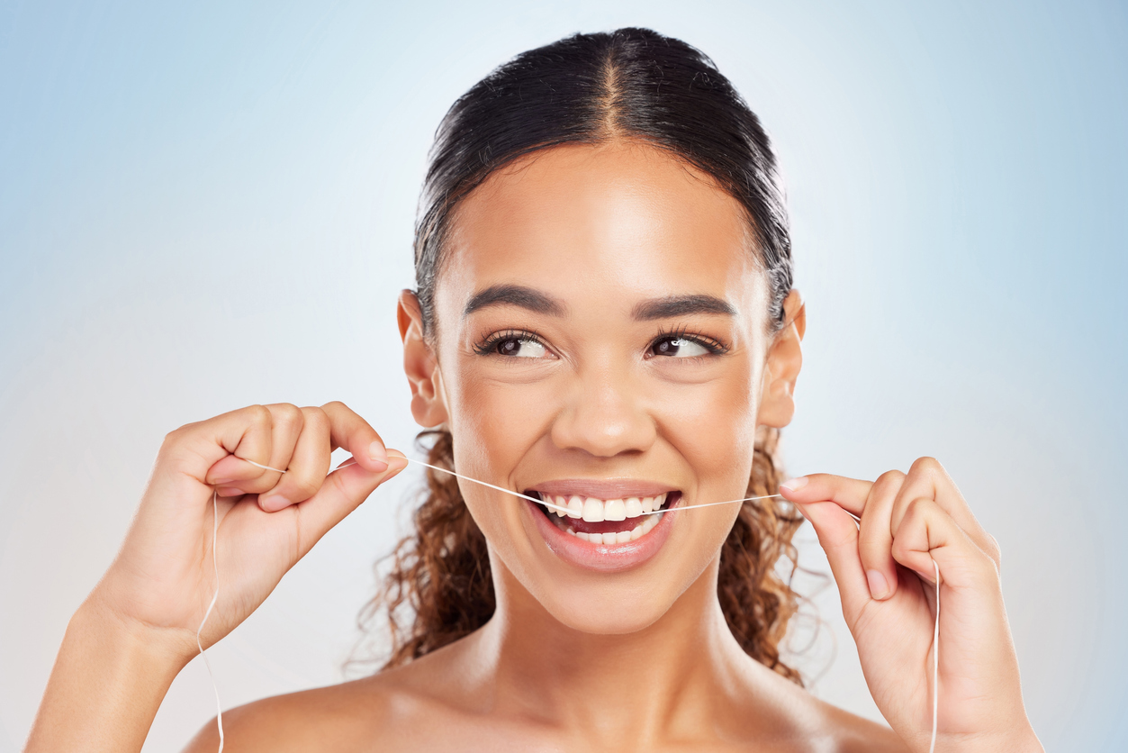 Woman smiling and flossing her healthy teeth