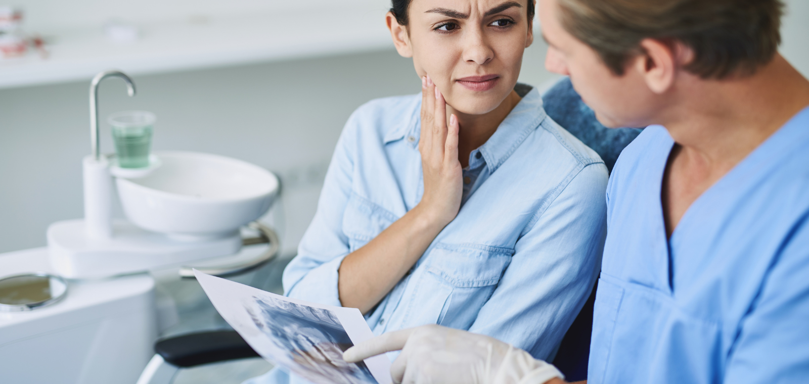 Dentist consulting with a patient about a broken dental crown emergency in Chicago