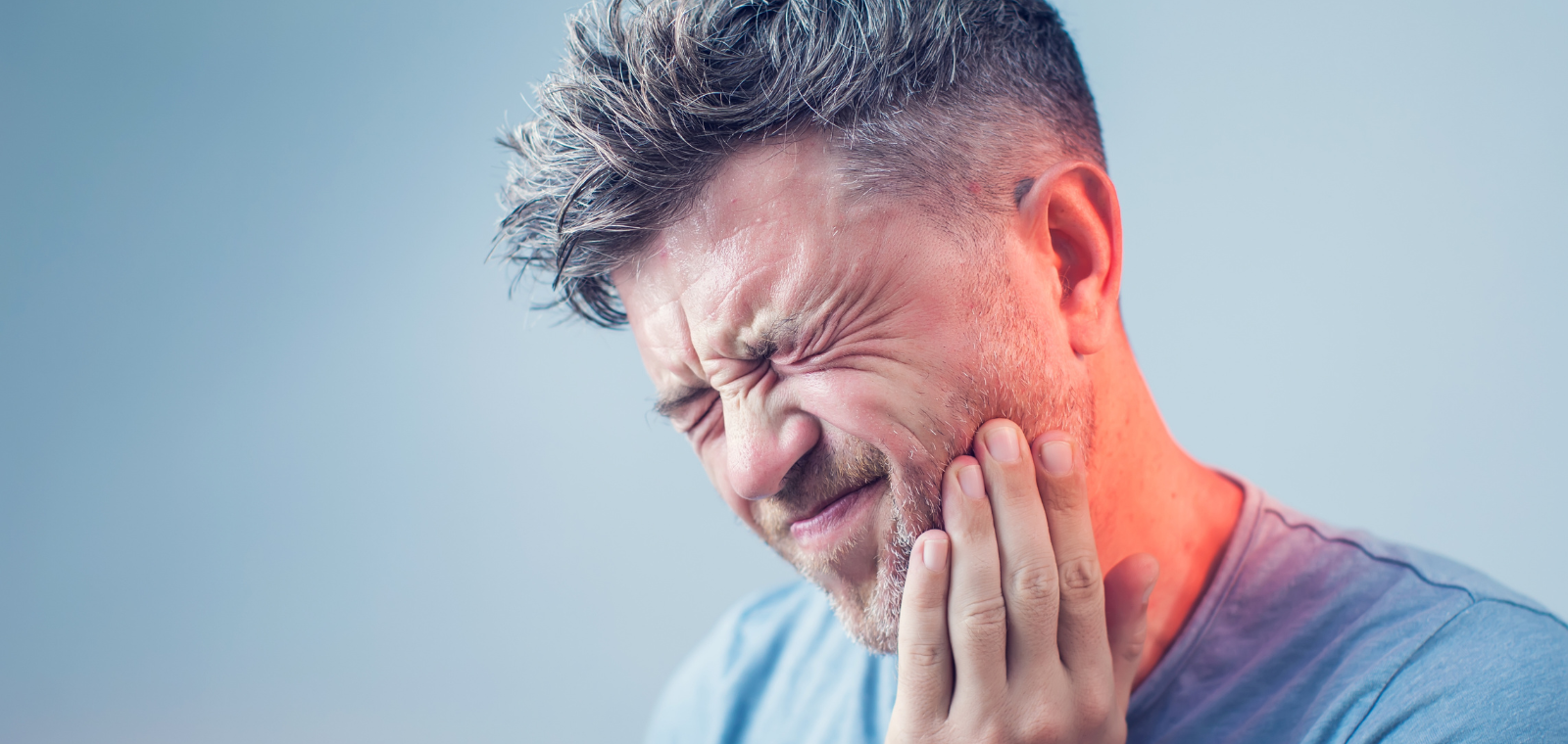 Patient in pain holding jaw due to a broken dental crown