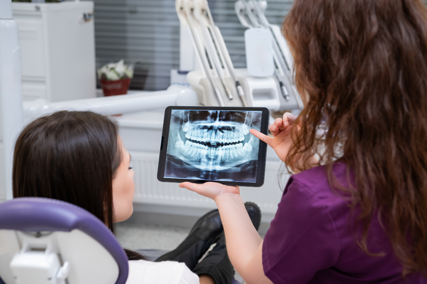 Dentist reviewing X-ray with patient during implant consultation at Art of Modern Dentistry